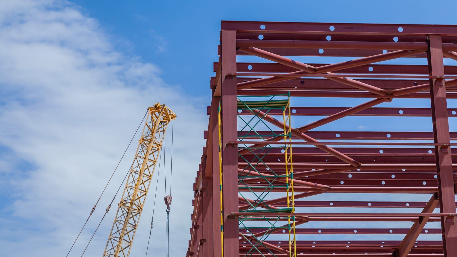 Grúa izando una viga de acero durante el montaje de una estructura metálica